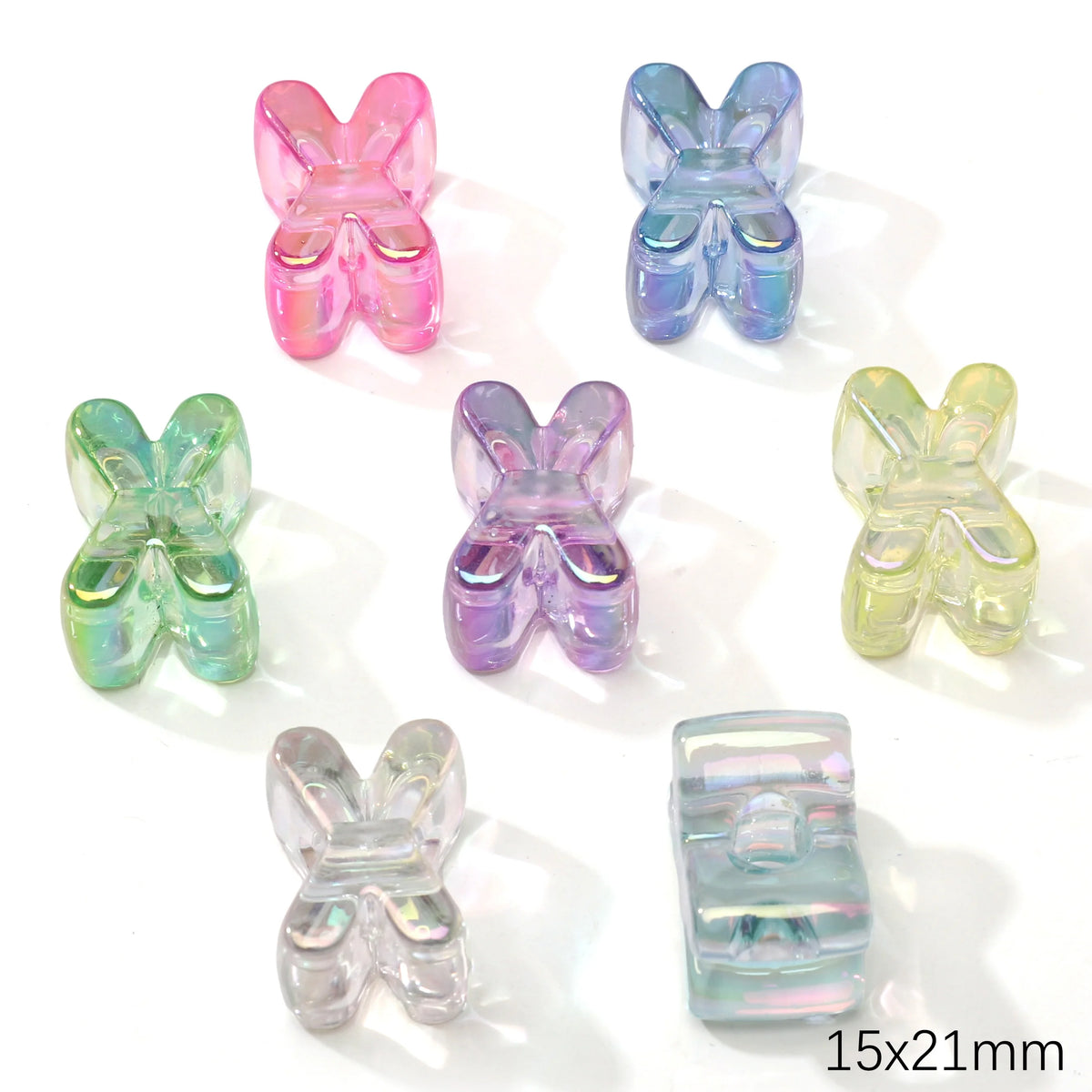 A collection of colorful acrylic butterfly shaped beads in pink, blue, green, and purple.