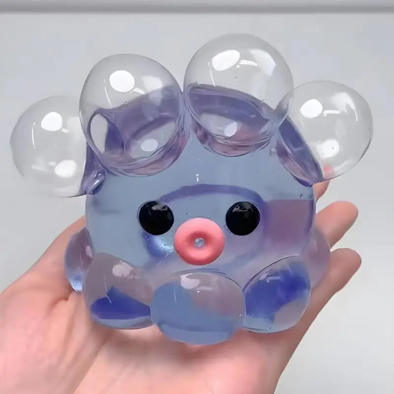 A translucent purple octopus squishy stress ball with round eyes and soft, bubbly texture being held in a hand.