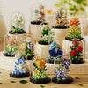 A collection of glass cloches filled with miniature flowers and greenery, showcasing various colors and arrangements.
