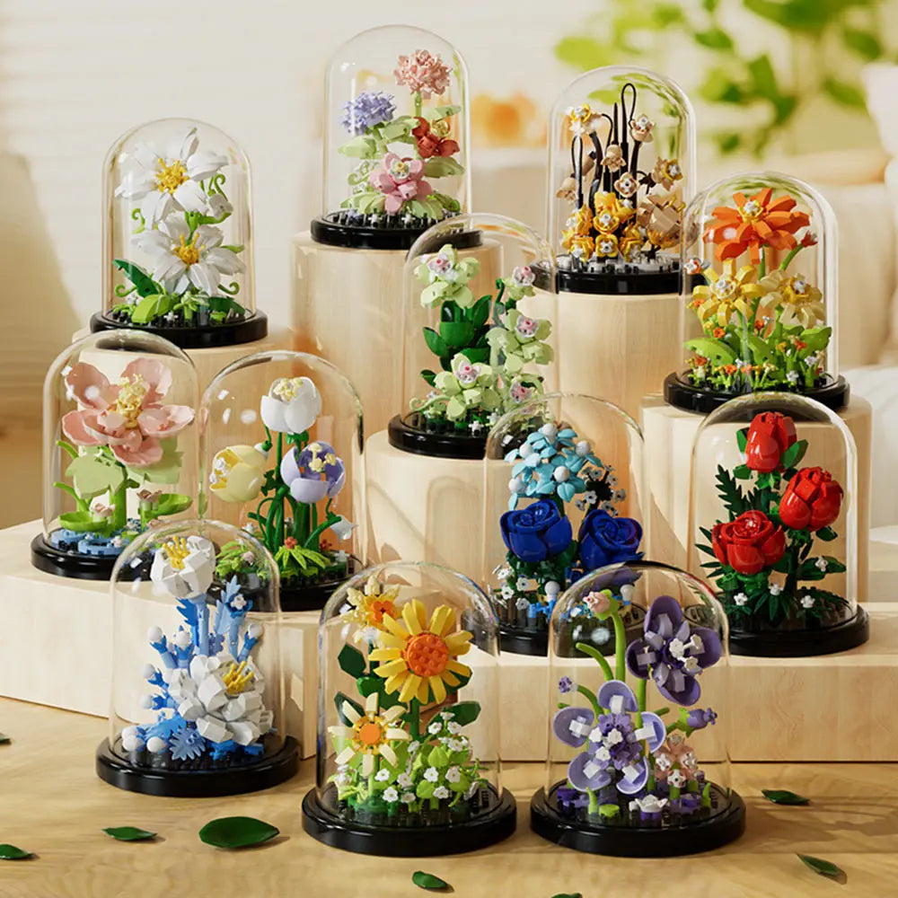 A collection of glass cloches filled with miniature flowers and greenery, showcasing various colors and arrangements.