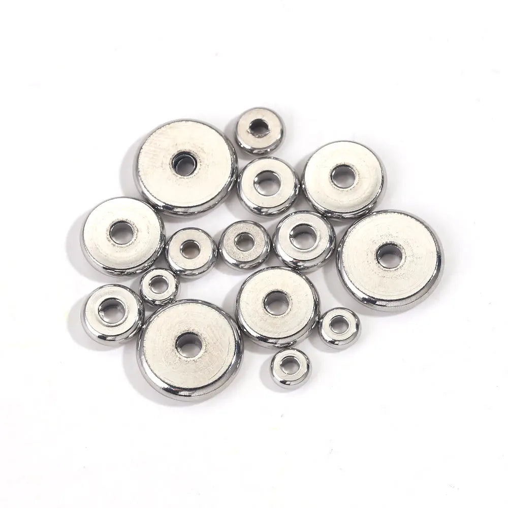 A collection of small, flat round stainless steel spacer beads for jewelry making.