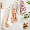 A set of five soft cotton muslin baby washcloths featuring various fruit patterns like apples and berries.