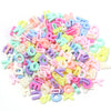 A pile of mixed acrylic letter beads in various pastel colors like pink, blue, yellow, and white.