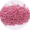 A pile of small, round metallic pink glass beads for jewelry making
