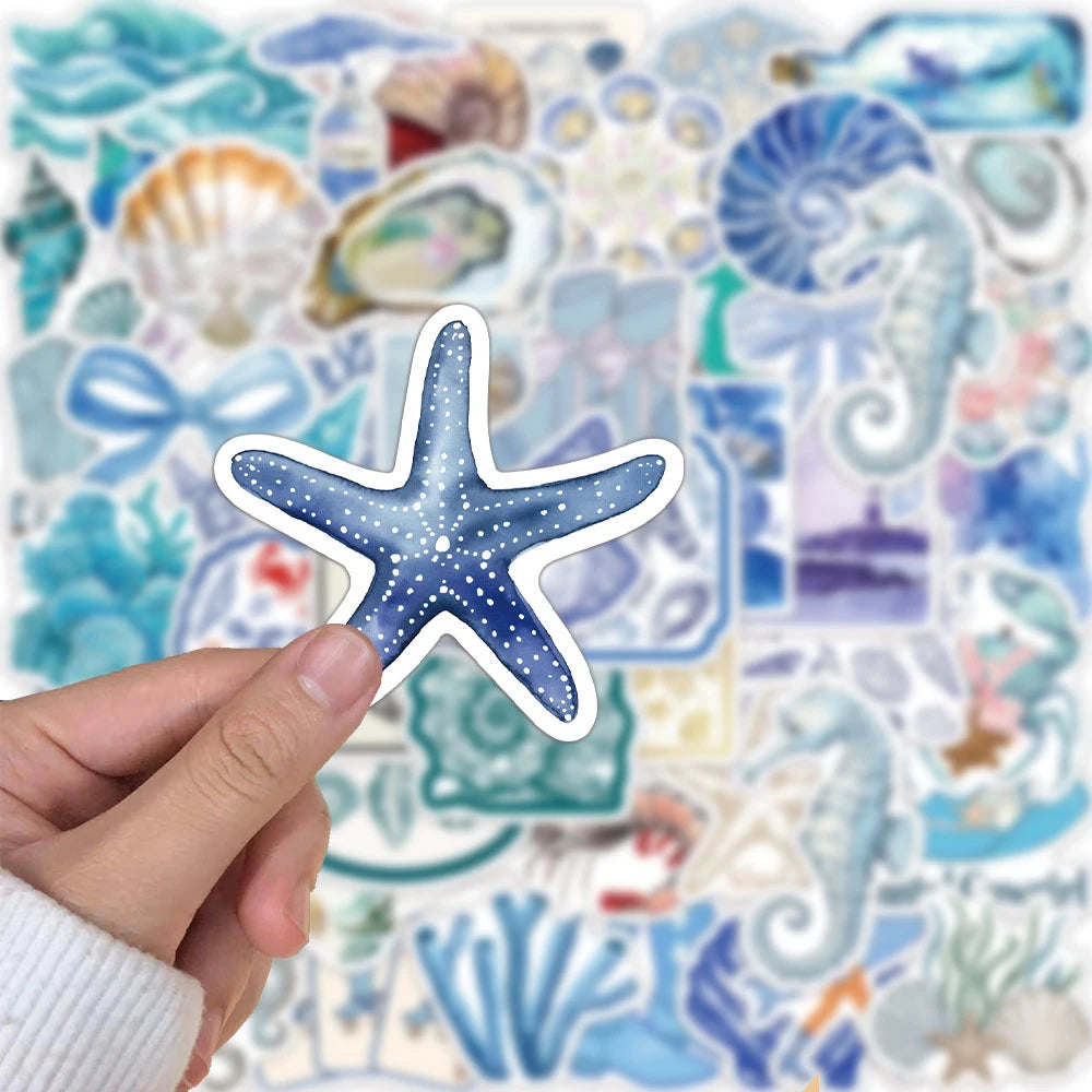 A hand holds a blue starfish shaped sticker against a background of various ocean creatures and sea life.
