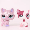 A pink and white Shorthair Cat bobble head figurine with purple accents.