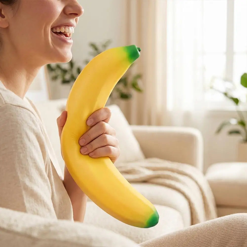 A woman is holding a bright yellow banana squishy stress relief toy.