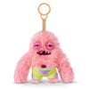 A pink fluffy plush monster with large eyes and a small mouth wearing lime green shorts, attached to a wooden keychain.