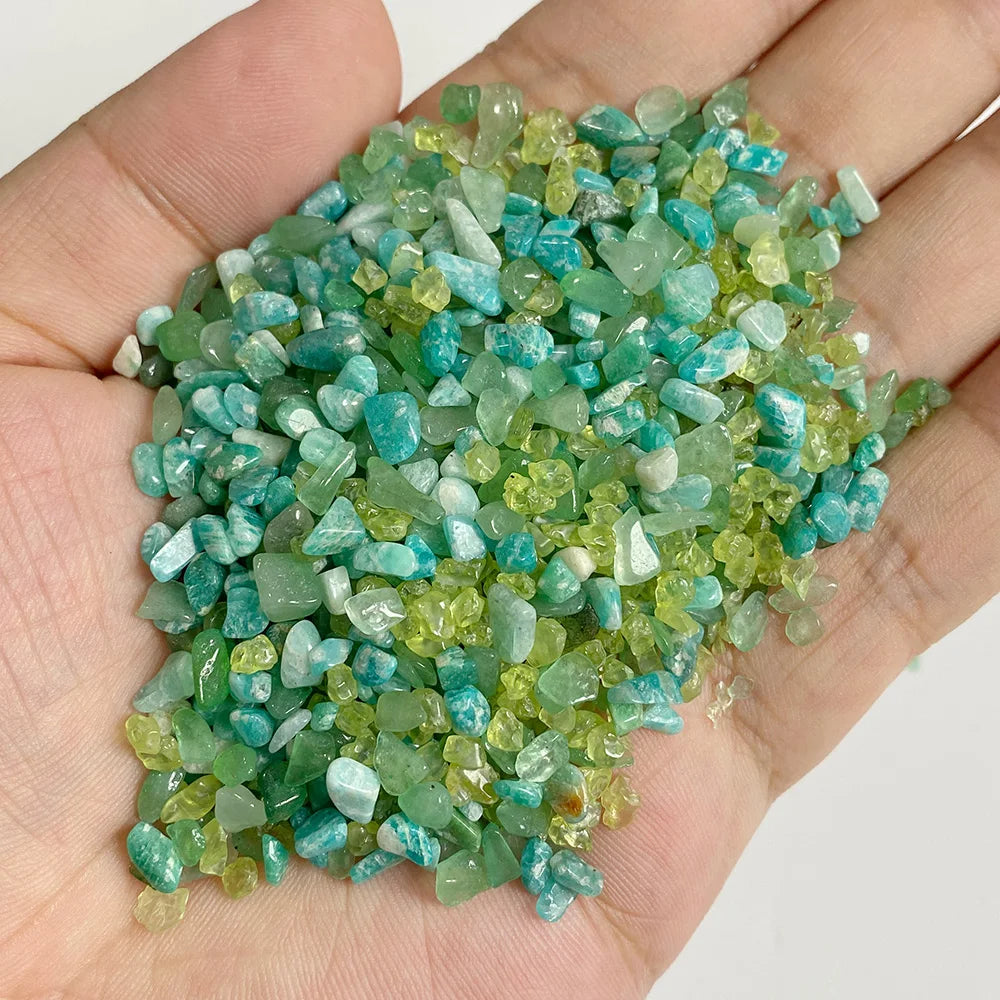 A handful of small, tumbled green and blue-green natural stone chips for jewelry making