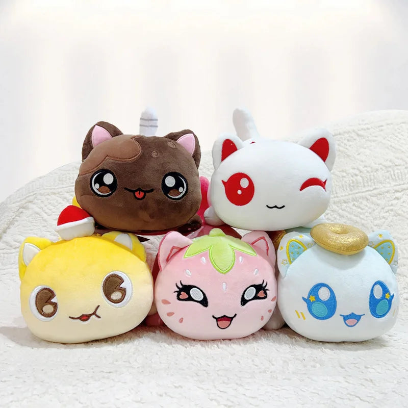 A collection of five plush cat dolls with various food accessories resting on a white textured surface.