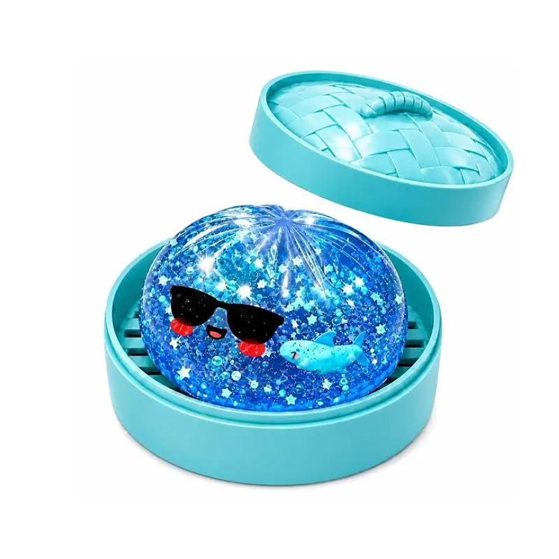 A blue glass sphere filled with glitter and featuring a fish face rests in a teal plastic container with a matching lid.