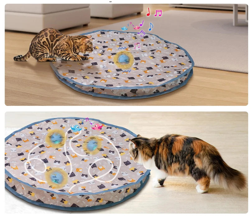 A tabby cat is playing with a motion-activated hide and seek toy shaped like a rolling ball on a light wooden floor.