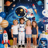 Five children posing in front of a large backdrop featuring planets and rockets for an outer space party decor set