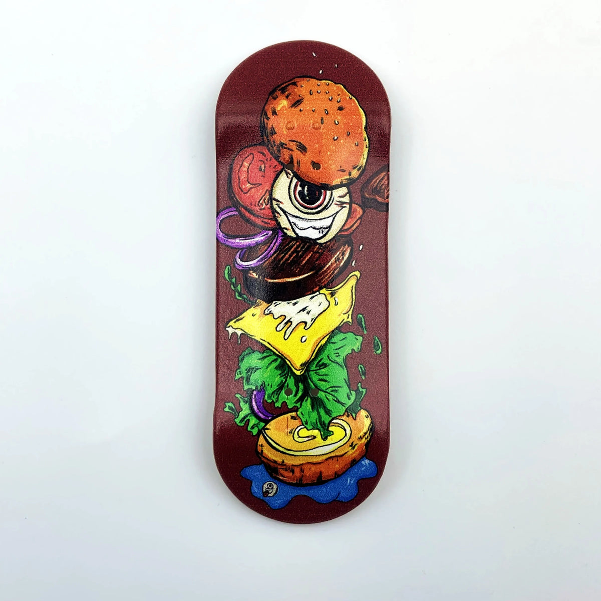 A wooden fingerboard deck featuring a vibrant UV-printed graphic of a hamburger and lettuce.