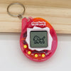 A pink electronic pet game toy with a digital screen and a metal keyring attached to a wooden surface.