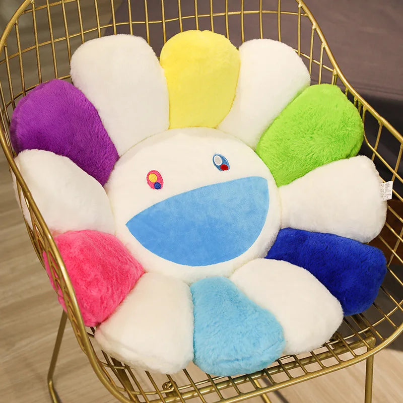 A large sunflower plush cushion with white petals and a yellow center is displayed in a gold wire basket.