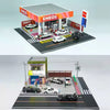 A 1:64 scale LED miniature car garage diorama showing a parking lot with several cars and an ENEOS branded building.