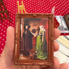 A small framed picture featuring two figures in historical attire, likely a blind ball from the Zuru Mini Brands Create Maste