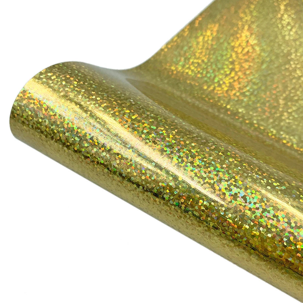 Close-up of a gold holographic glitter heat transfer vinyl material rolled into a tube.
