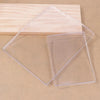 Clear silicone gel printing plates stacked on a wooden surface for mixed media art