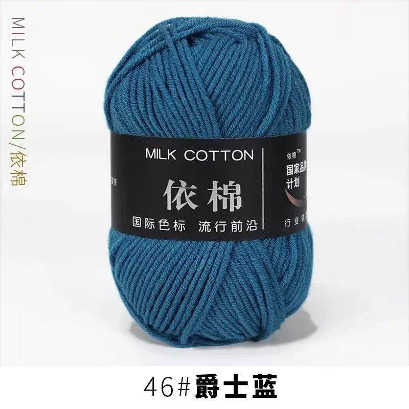 A skein of teal milk cotton yarn labeled with Chinese characters and a size designation.