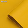 A close-up of a yellow leather material rolled up diagonally, showing its texture and color.