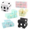 A collection of colorful and black fidget cubes in various shades of pink, mint green, and white.