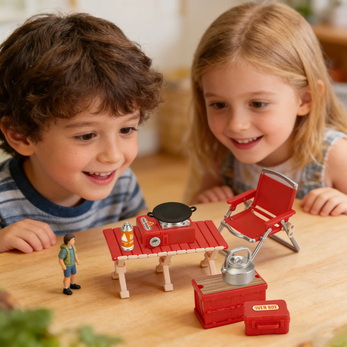 A child is playing with a miniature red camping picnic set and accessories on a wooden table.