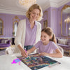 A woman and a girl are painting a colorful cat fantasy scene using a diamond painting kit.