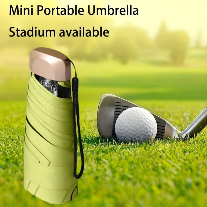 A lime green mini portable umbrella is shown next to a golf ball on a grassy field.