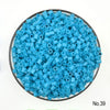 A pile of small, round, light blue plastic fuse beads for crafting.