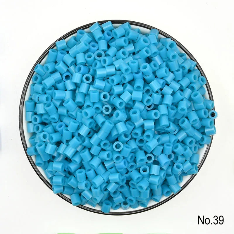 A pile of small, round, light blue plastic fuse beads for crafting.
