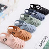 A collection of girls' gladiator jelly sandals in various colors including black, gray, blue, and nude tones.