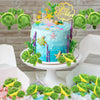 A set of twelve adorable mini sea turtle plush toys in various shades of green and yellow decorating a cake.