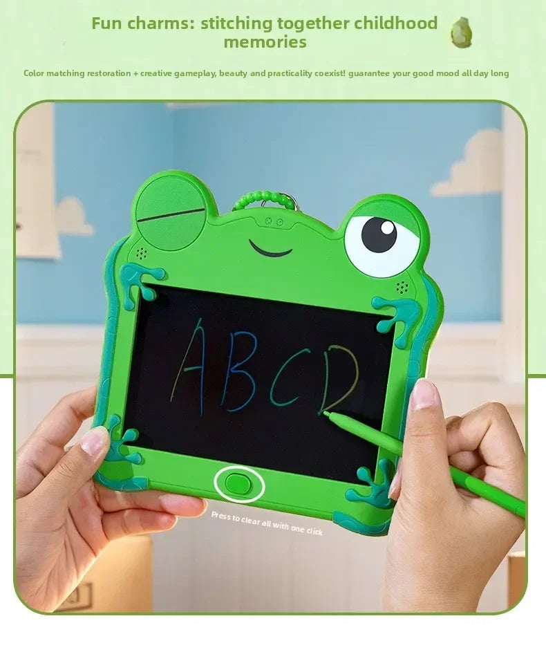 A child's hand holds a green frog-shaped LCD drawing tablet with the letters ABCD displayed on the screen.