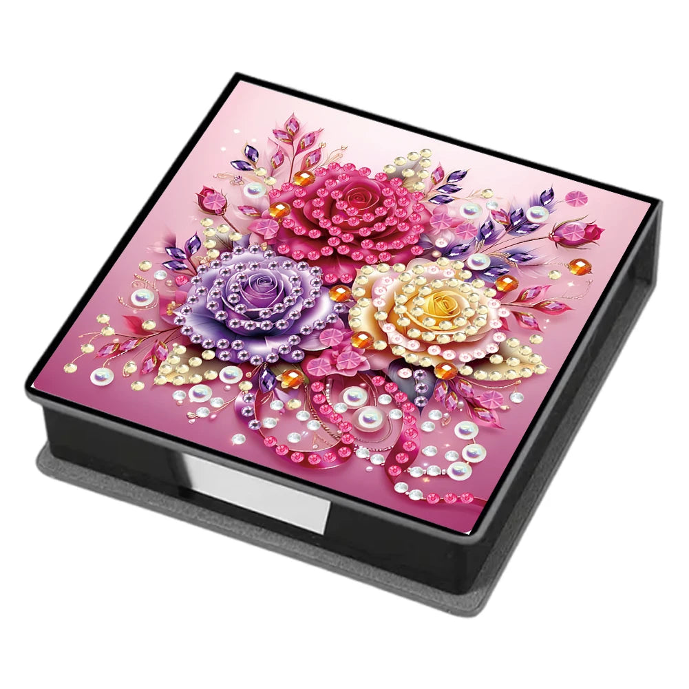 A leather box containing a diamond painting kit featuring colorful floral designs on a pink background