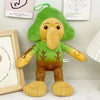 A soft green and tan plush toy shaped like a shark with large eyes and floppy limbs.