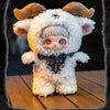 A fluffy white plush doll with brown horns and a dark ribbon detail sitting on a wooden surface.