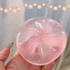 A hand holds a clear pink squishy stress relief toy shaped like a tooth.