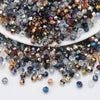 A pile of multicolor faceted glass crystal beads in various sizes and shapes for jewelry making