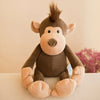 A brown jungle animal plush toy with large ears and a fluffy tuft on top, sitting on a white surface.