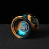 A close-up of a professional aluminum alloy yo-yo with a gold and blue design featuring a tiger head.