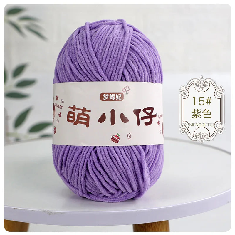 A ball of purple chenille yarn labeled with Chinese characters is displayed on a white table.