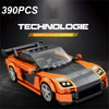 An orange and black sports car model built from building blocks, displayed on a dark surface.