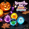 A collection of glowing Halloween-themed squishy toys including a pumpkin, a ghost, and other spooky figures displayed on a d