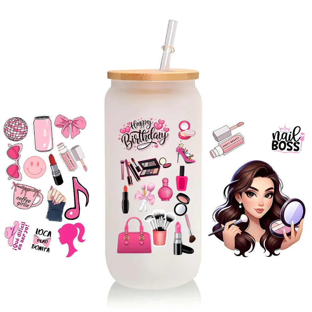 A clear tumbler with a pink and gold design featuring various makeup items and a woman's portrait.