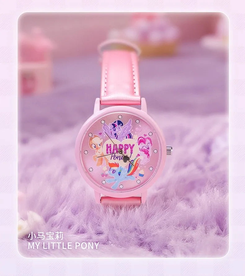 A pink watch featuring a pony design and glitter accents, displayed on a purple fuzzy surface.