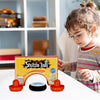 A young child is playing with a mini floating air hockey set, including two orange pushers and a black puck.