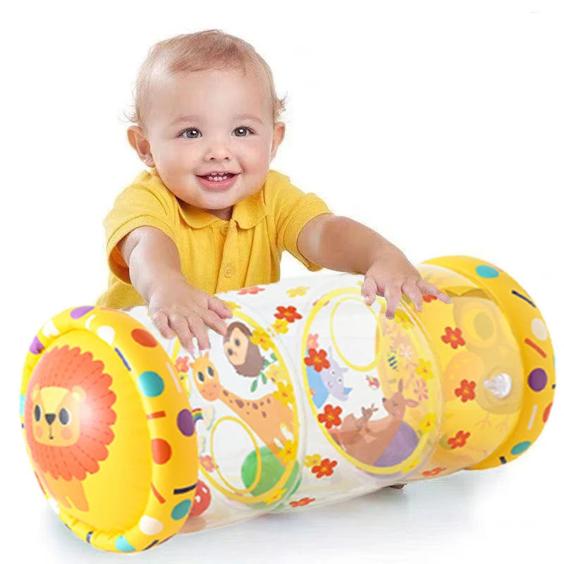 A smiling baby is interacting with a yellow and orange Montessori baby crawling roller toy.