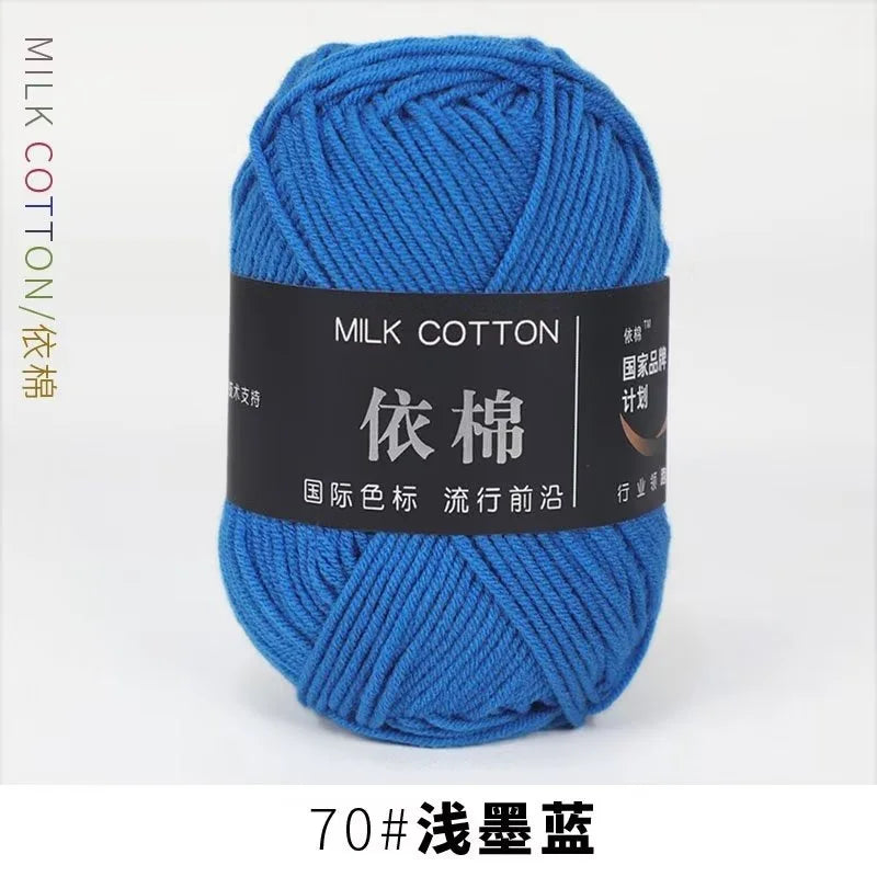 A skein of bright blue milk cotton yarn labeled with Chinese text and a weight designation.